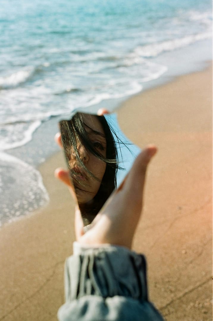 a woman looking at a broken mirror