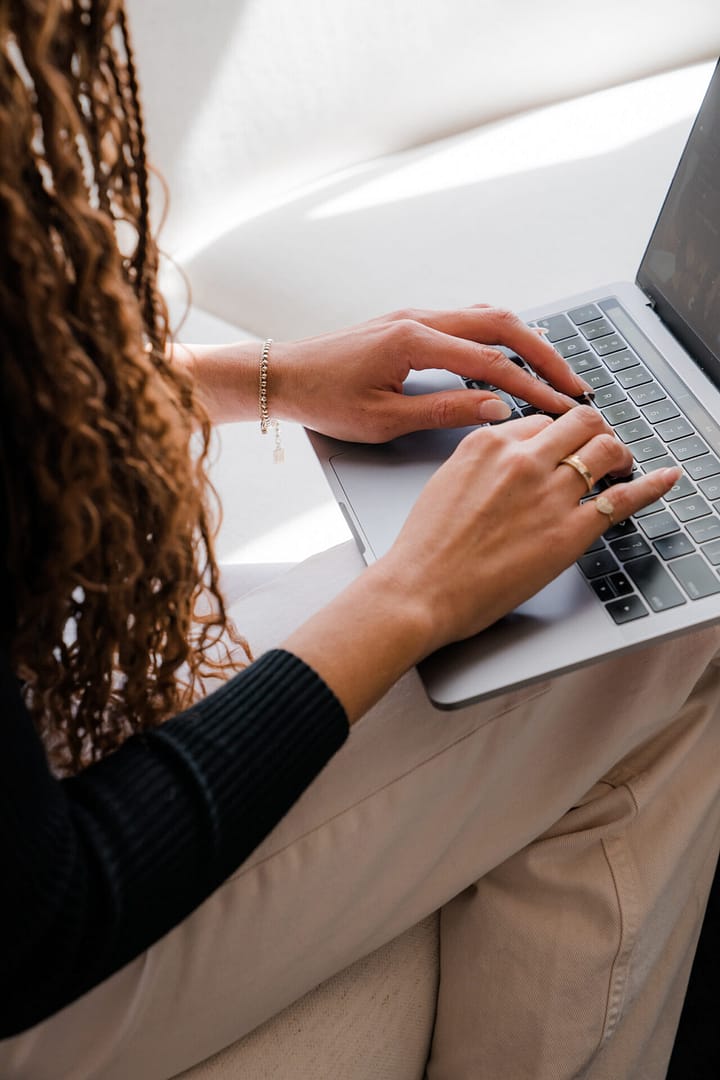 a woman typing on a laptop