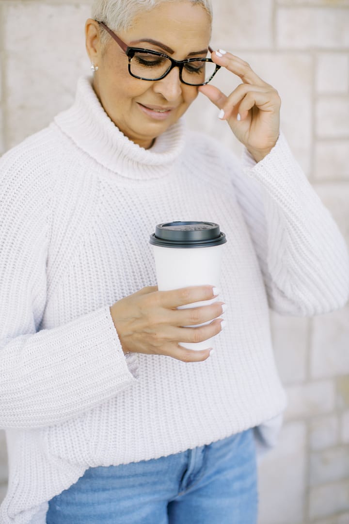 a woman holding a cup of coffee or tea