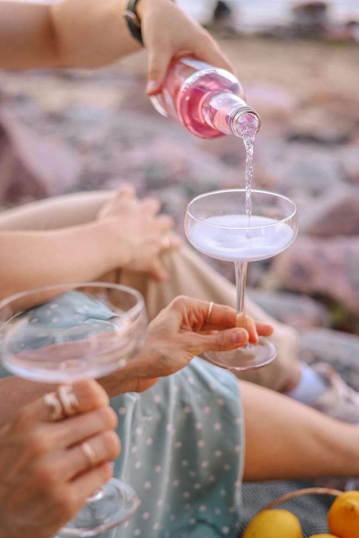 a person pouring liquid into a glass