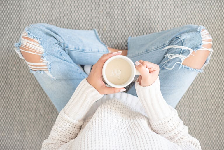 women sitting on the floow with a cup of coffee