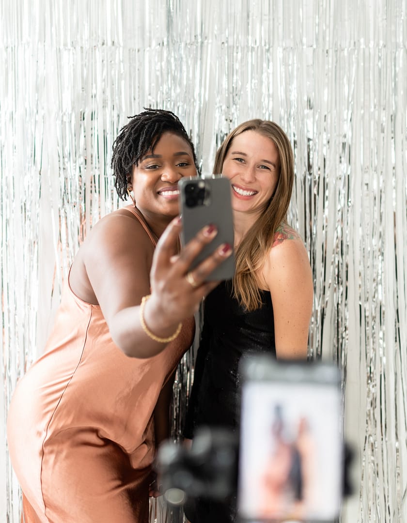 a white woman and black woman taking a phot on a phone together